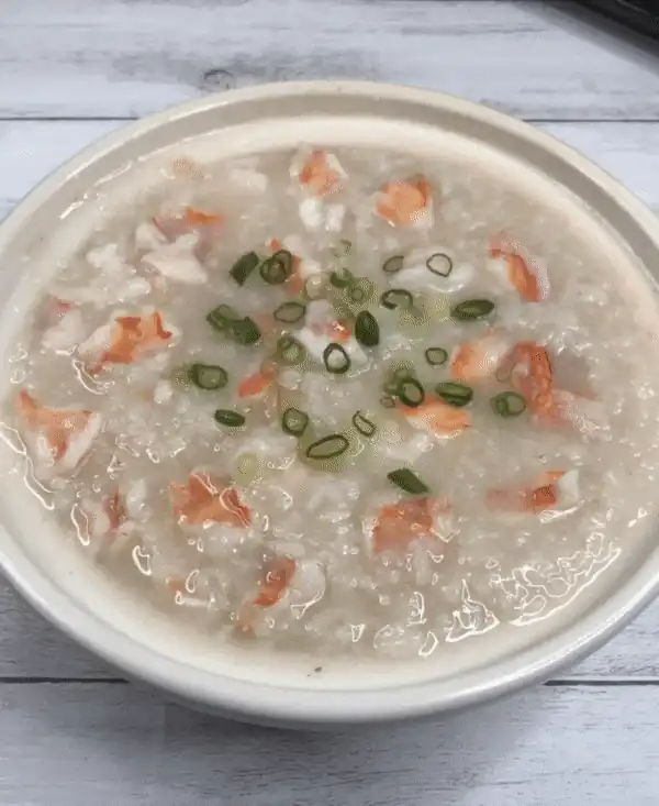 Lifting the lid to reveal the finished shrimp congee, steam rising